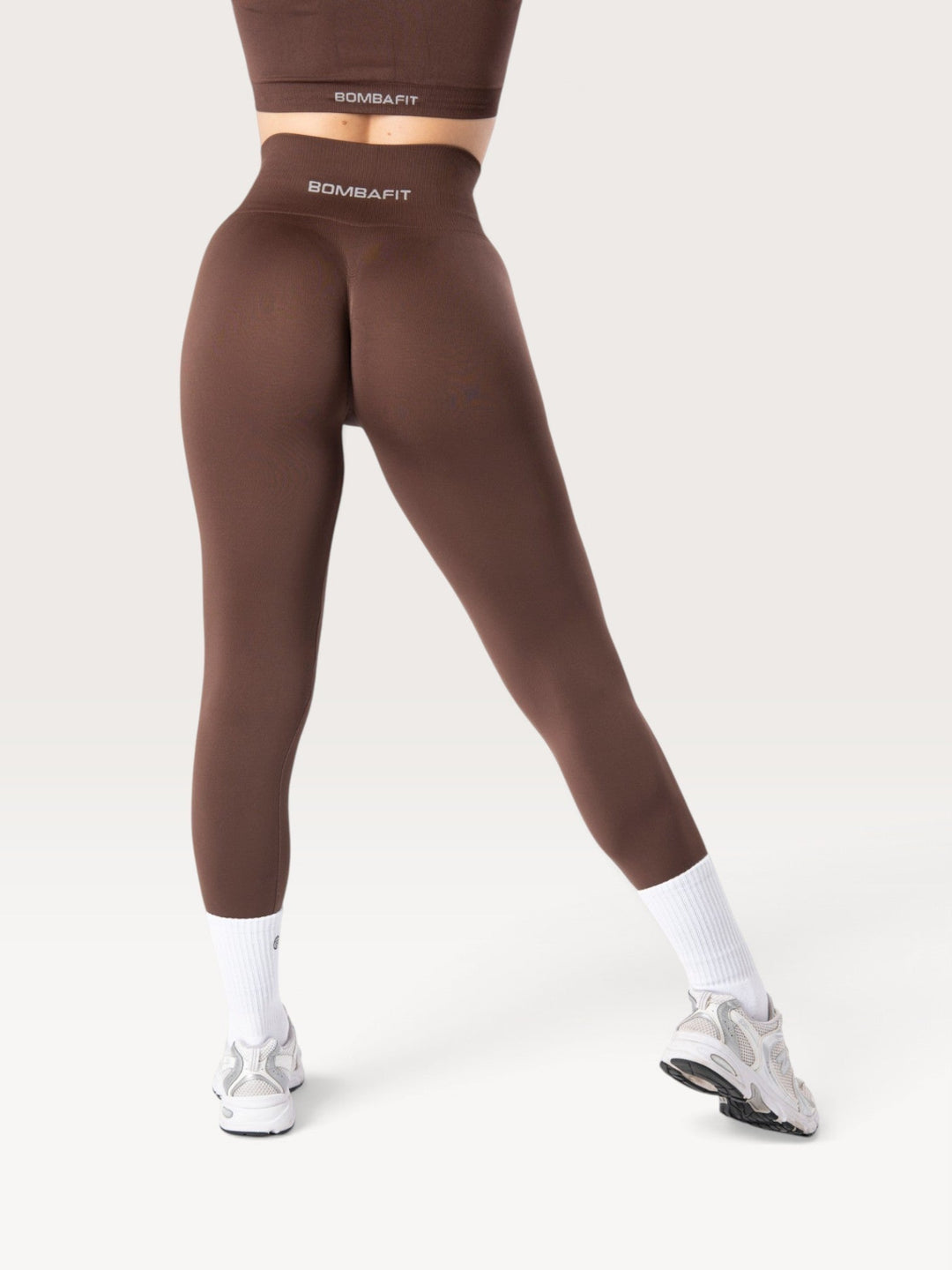 Leggings Bombafit Everyday Seamless marroni a vita alta con logo, indossati da una modella vista da dietro