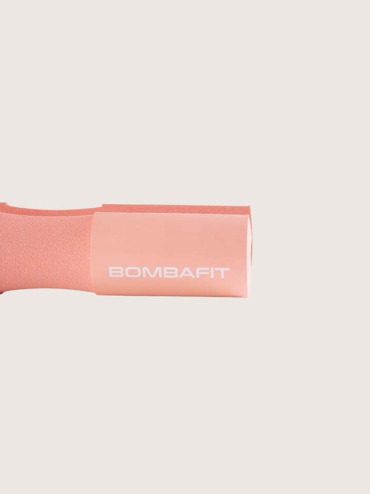 Protezione imbottita per bilanciere Bombafit di colore rosa, ideale per comfort durante gli esercizi di sollevamento
