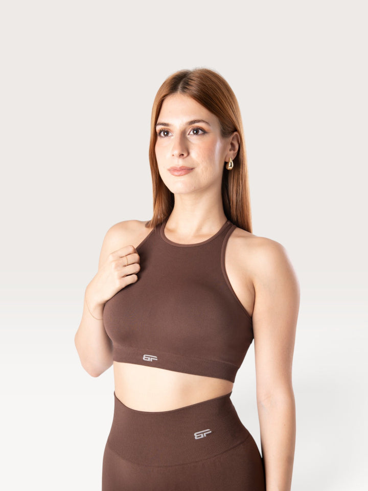 Modella indossa il top sportivo marrone Bombafit Go Seamless con scollo alto e design senza cuciture