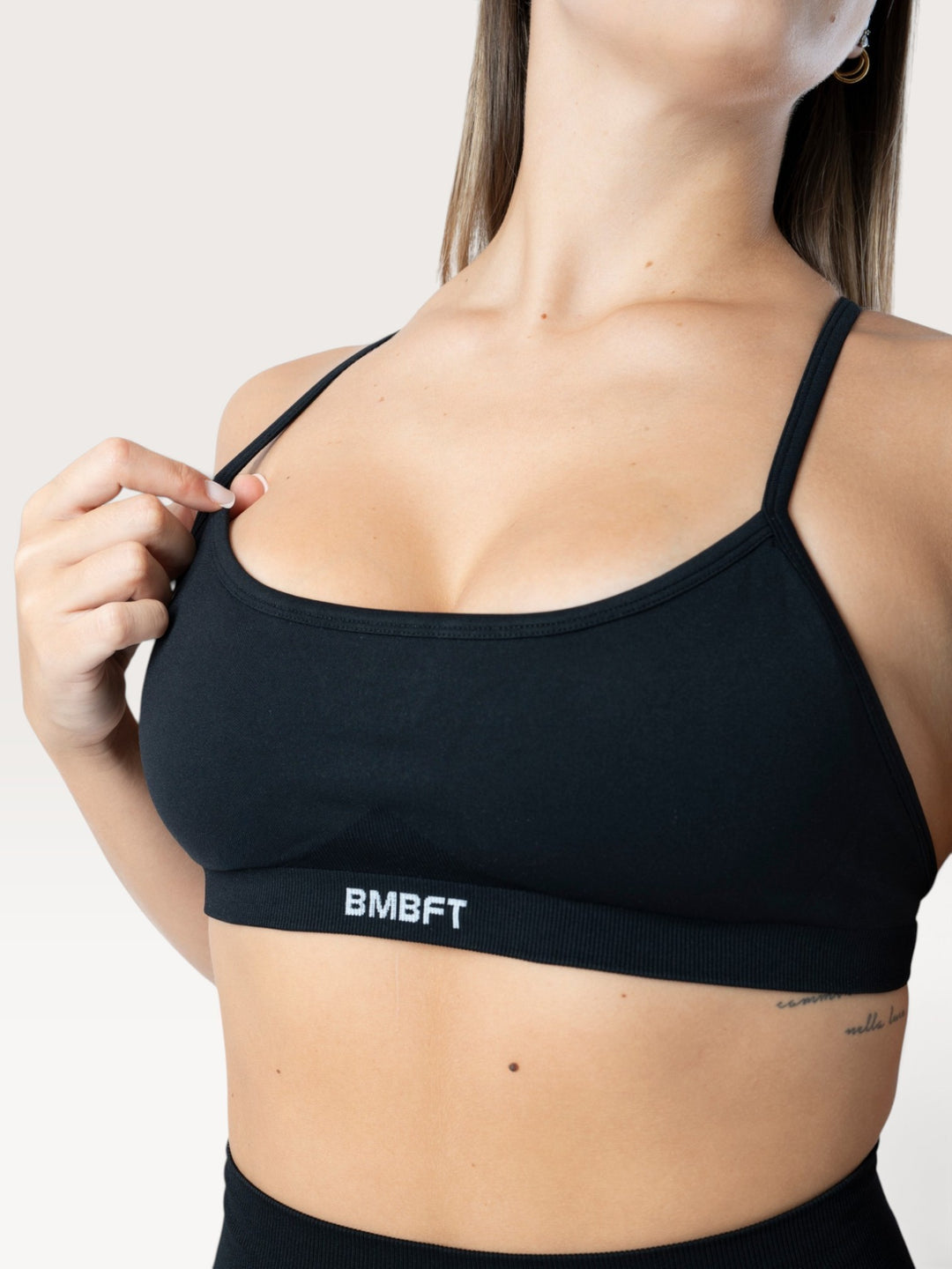 Top sportivo nero Bombafit con spalline sottili, banda elastica sotto il seno e tessuto traspirante seamless